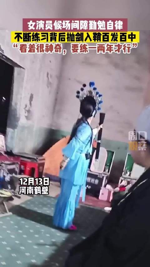 戏曲演员候场间隙，反复练习背后抛剑入鞘百发百中……