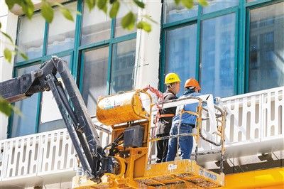 江苏省宿迁市泗阳县一老旧小区改造施工现场，工人们正进行小区外墙空调机防护架和装饰构件施工。 裴 成摄（人民视觉）