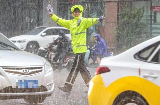 图为一名交警在雨中指挥交通。（沈阳市公安局交通警察局供图）