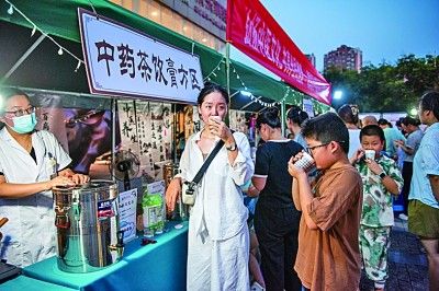 在安徽芜湖一中医药文化夜市上，市民品尝中药茶饮。肖本祥摄/光明图片