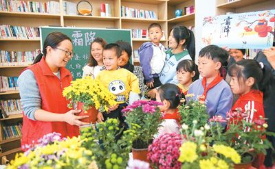 10月19日，在江苏省如皋市城南街道肖陆村农家书屋，小朋友赏菊花、学习霜降节气习俗。徐 慧摄（人民视觉）